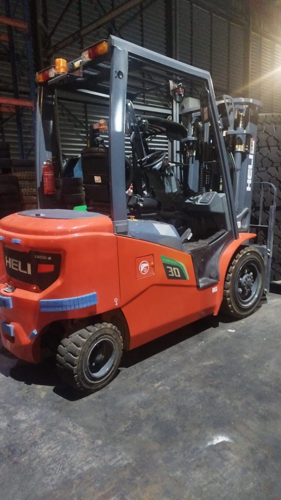 Forklift kecil merah siap operasional di gudang