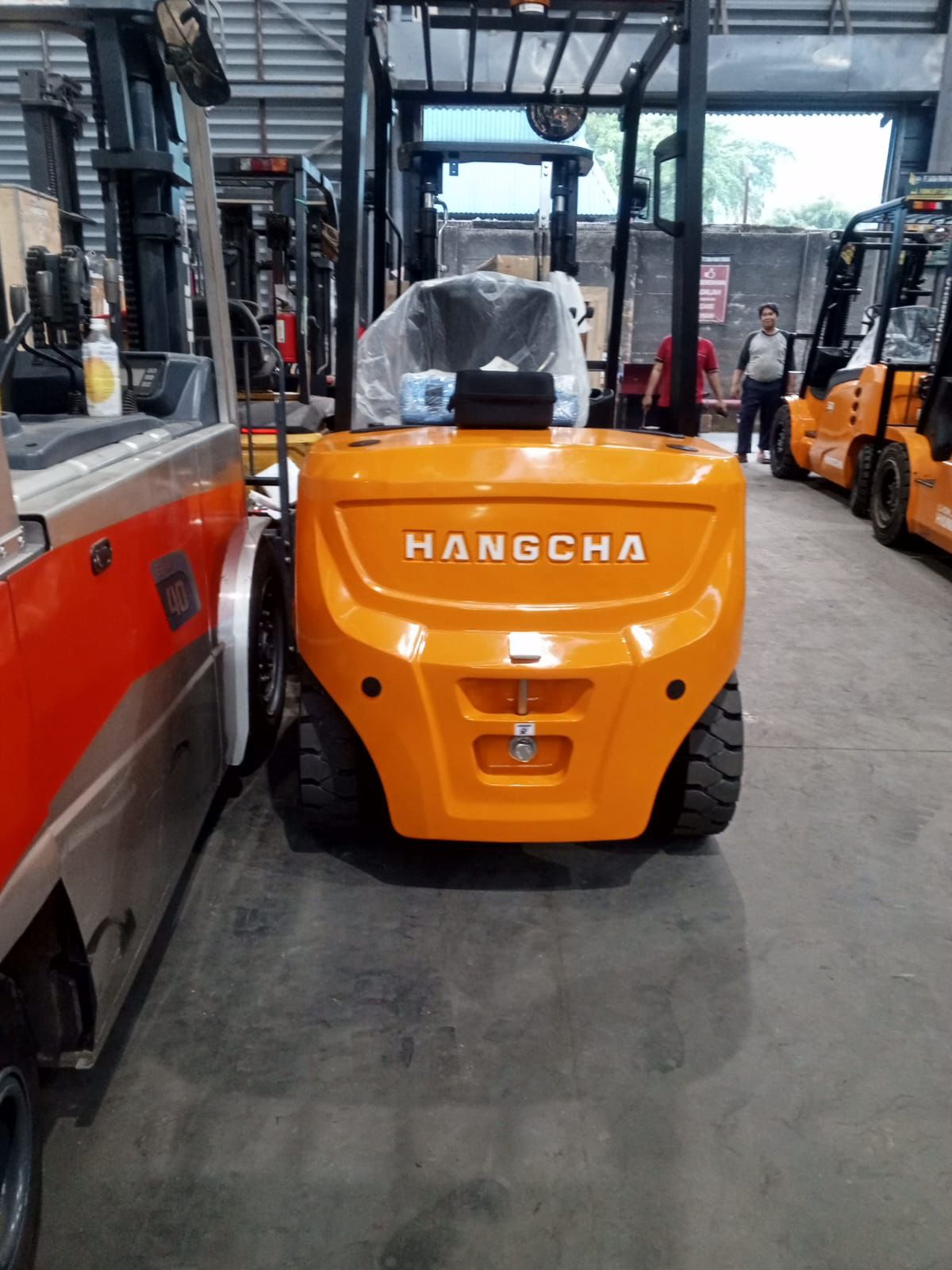 Forklift merah dengan detail bodi dan ban di area workshop