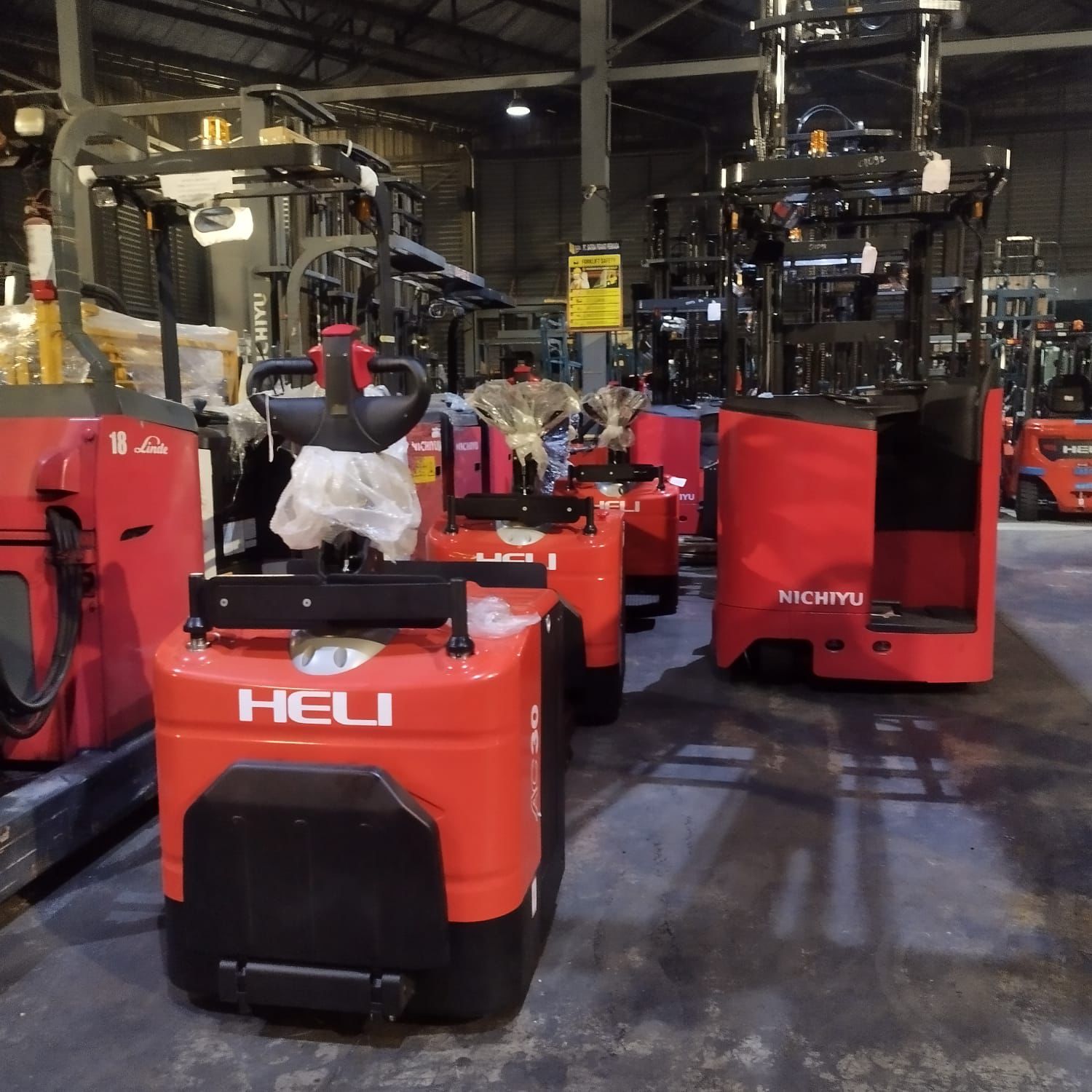 Reach truck oranye siap operasional di dalam gudang