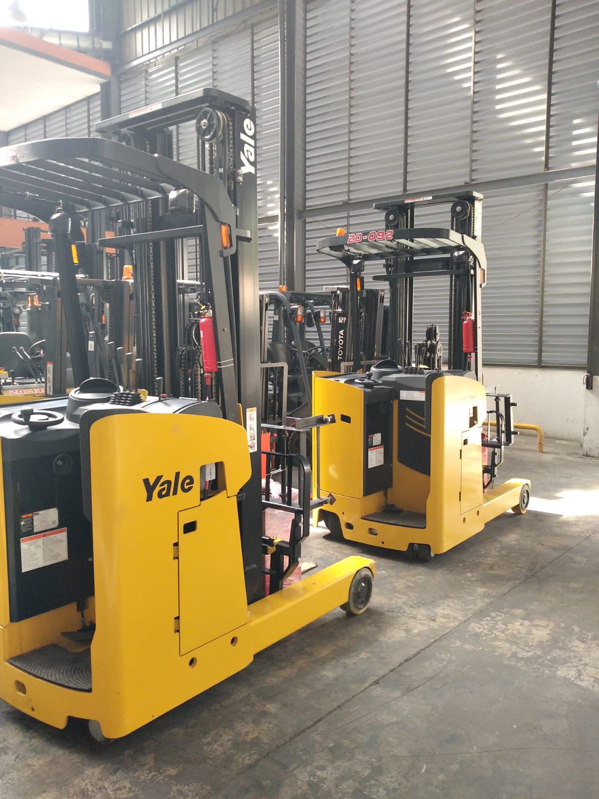 Forklift hijau dan merah dalam area armada workshop